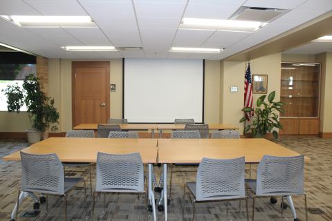 An open area with screen. Tables and chairs are provided upon request.